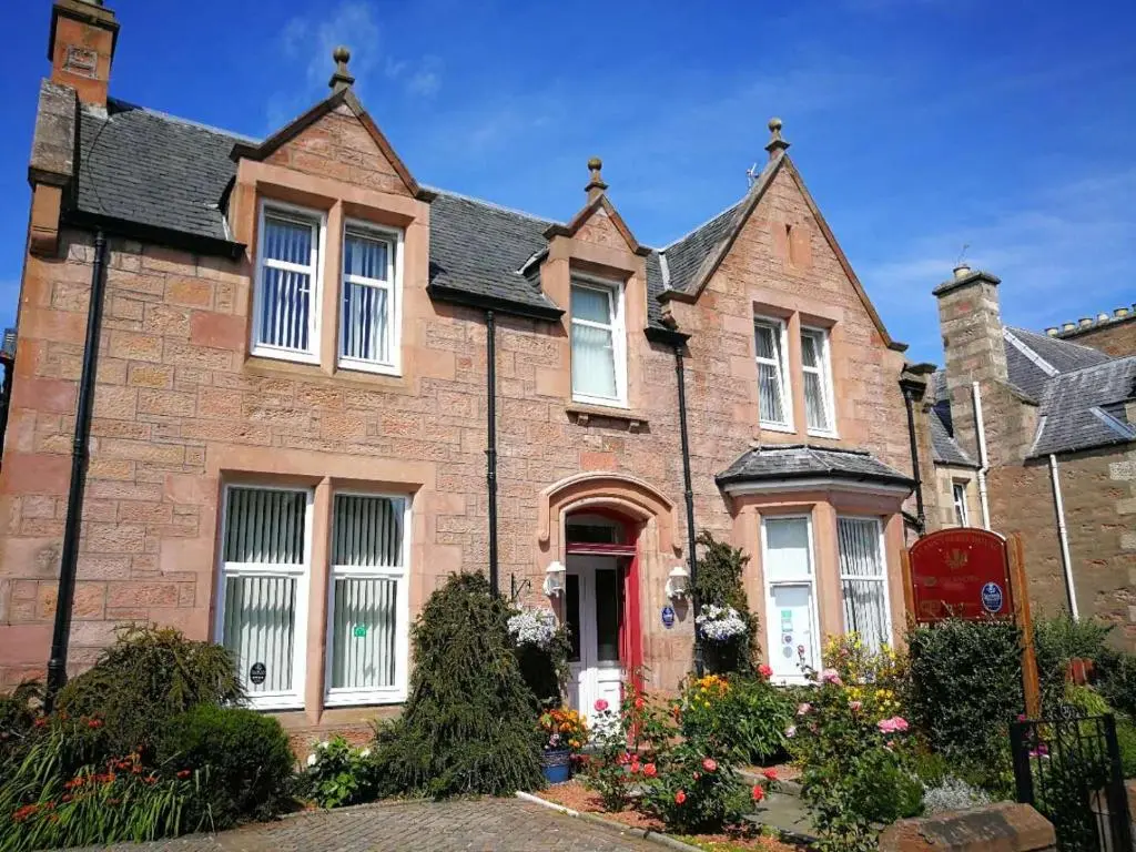 a large brick house with a red door at St Ann\u2019s Guest House in Inverness