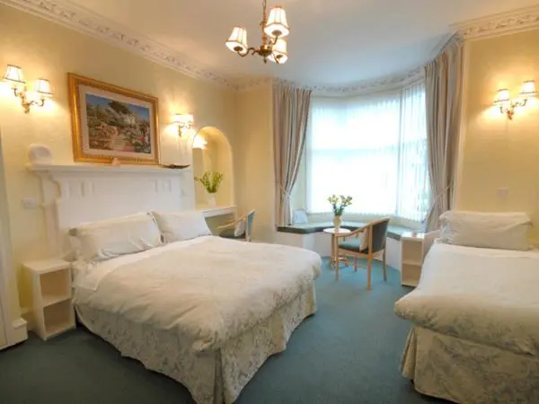 a hotel room with two beds and a table at St Ann\u2019s Guest House in Inverness
