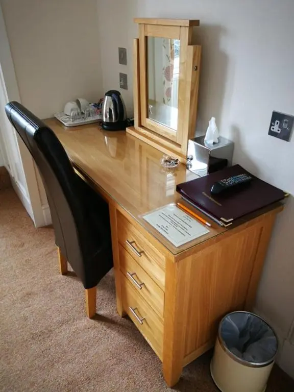 a wooden desk with a chair and a mirror at St Ann\u2019s Guest House in Inverness