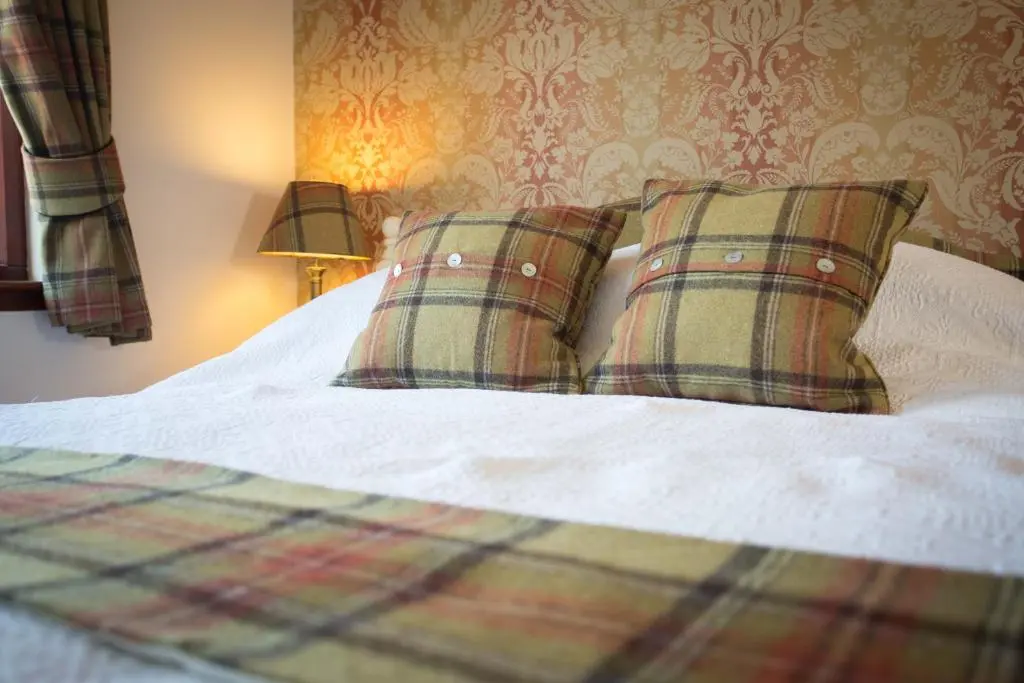 a bedroom with a bed with two pillows on it at Leanach Farm in Inverness