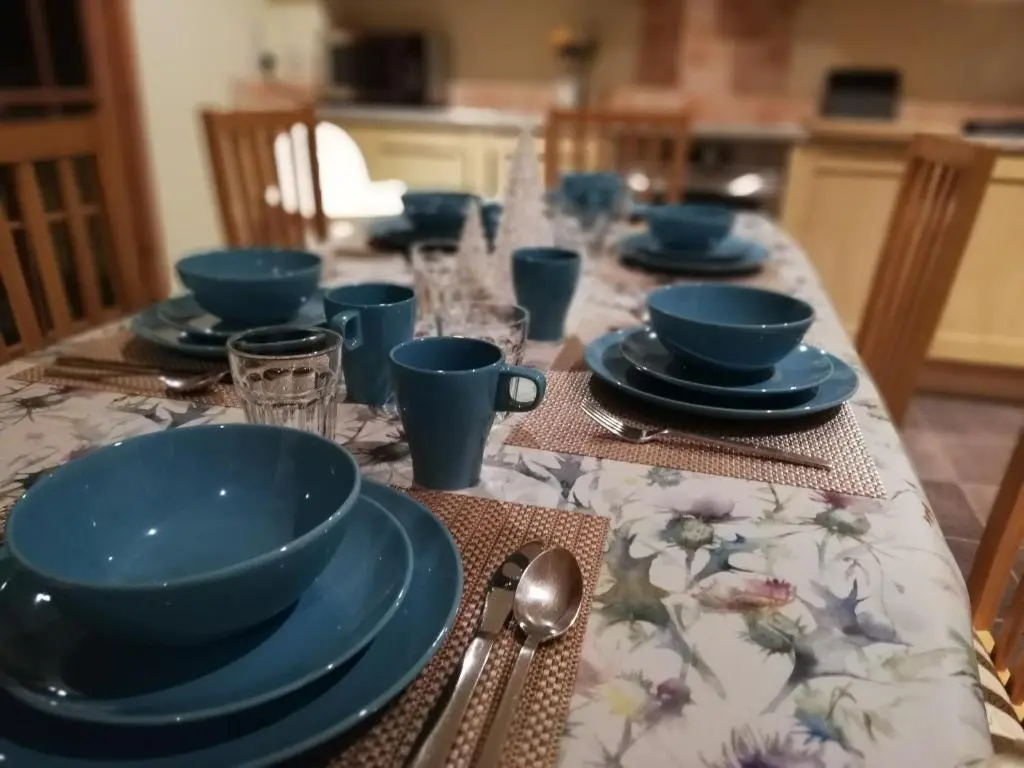 a table with blue bowls and plates on it at Holiday House Kinveachy in Aviemore