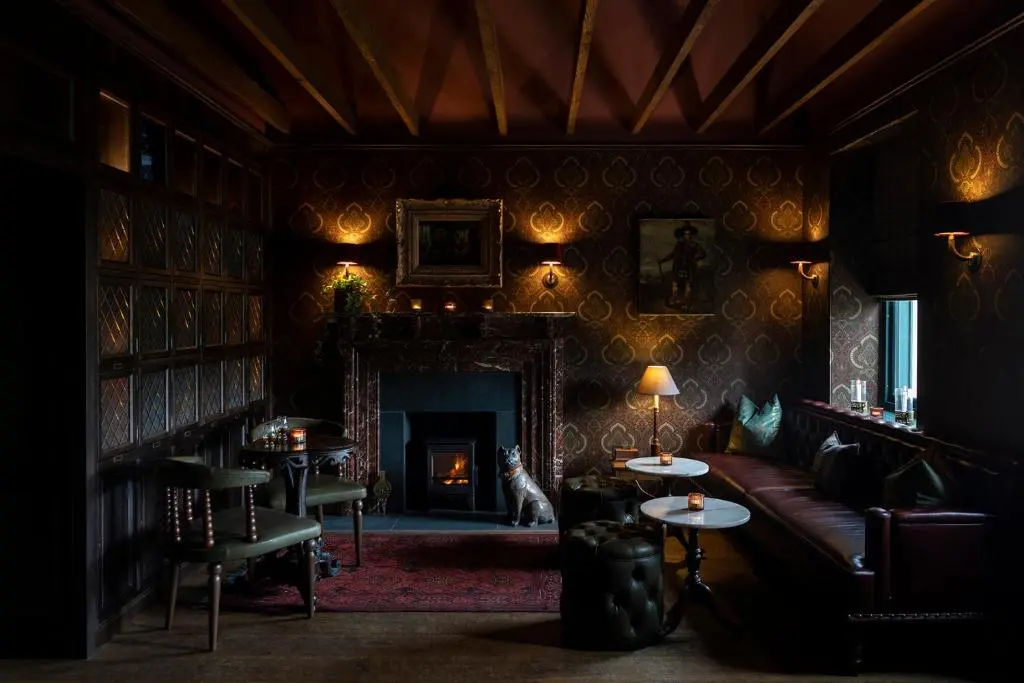 a living room with a couch and a fireplace at Kildrummy Inn in Kildrummy
