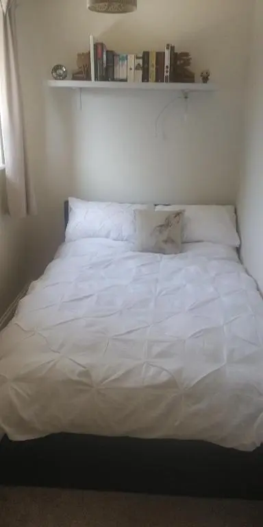 a bed with white sheets and pillows in a bedroom at The Little House by the Ness in Inverness