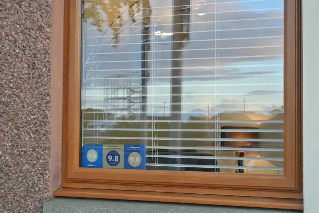 a window with blinds on it with a view of a train at The Little House by the Ness in Inverness