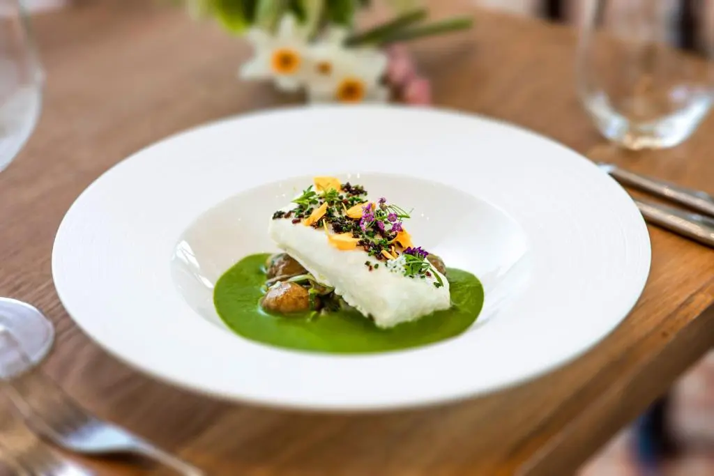 a white plate with a piece of food on a table at Douneside House in Tarland