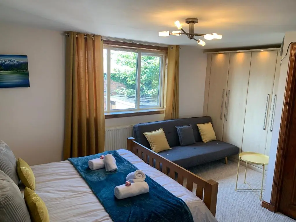 a bedroom with a bed and a couch at Drumdale Bed and Breakfast in Inverness