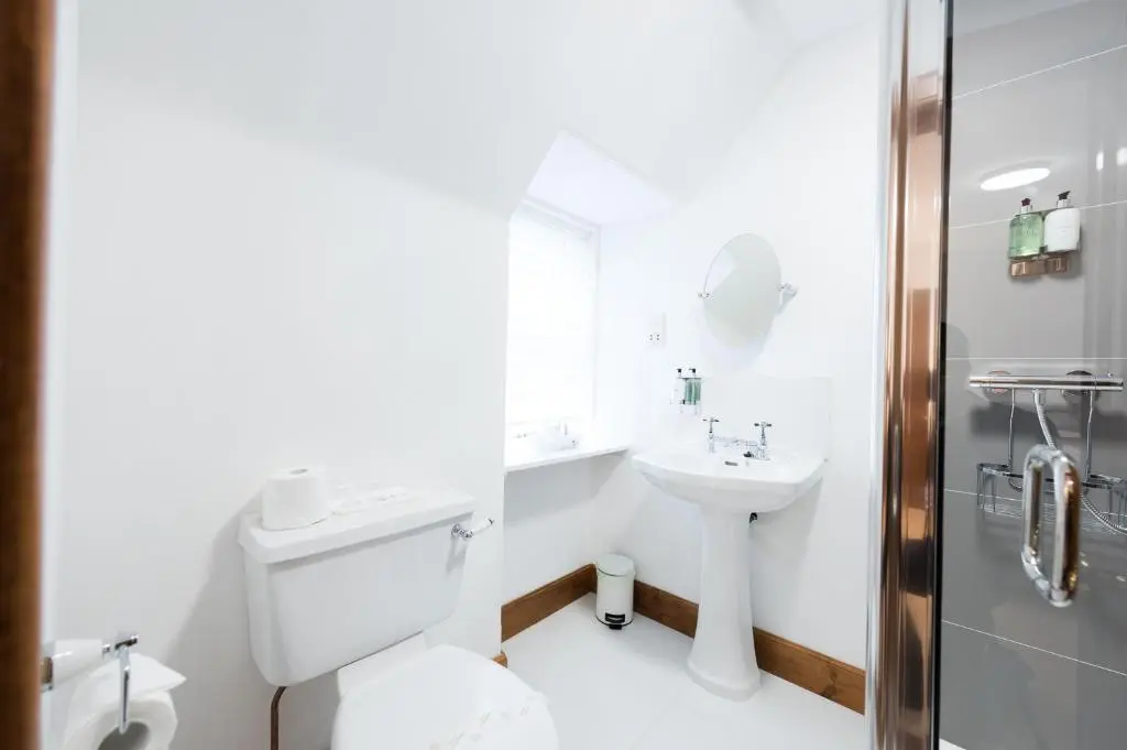 a white bathroom with a sink and a toilet at Balloan House in Dornoch