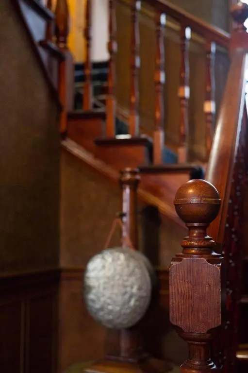 a stairway with a wooden railing and a stair case at Balloan House in Dornoch