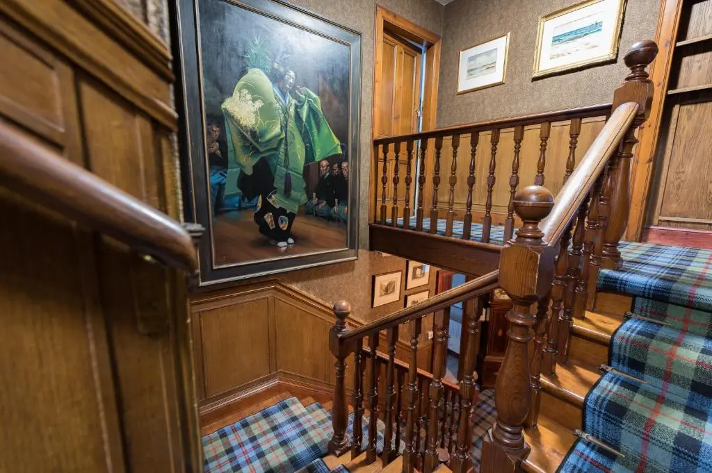 a staircase in a house with a painting on the wall at Balloan House in Dornoch