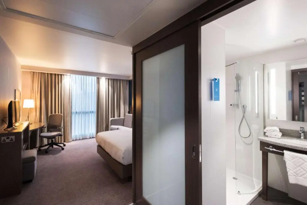 a hotel room with a bed and a bathroom at Hampton By Hilton Aberdeen Airport in Dyce