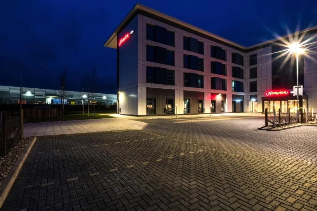 an empty parking lot in front of a building at night at Hampton By Hilton Aberdeen Airport in Dyce