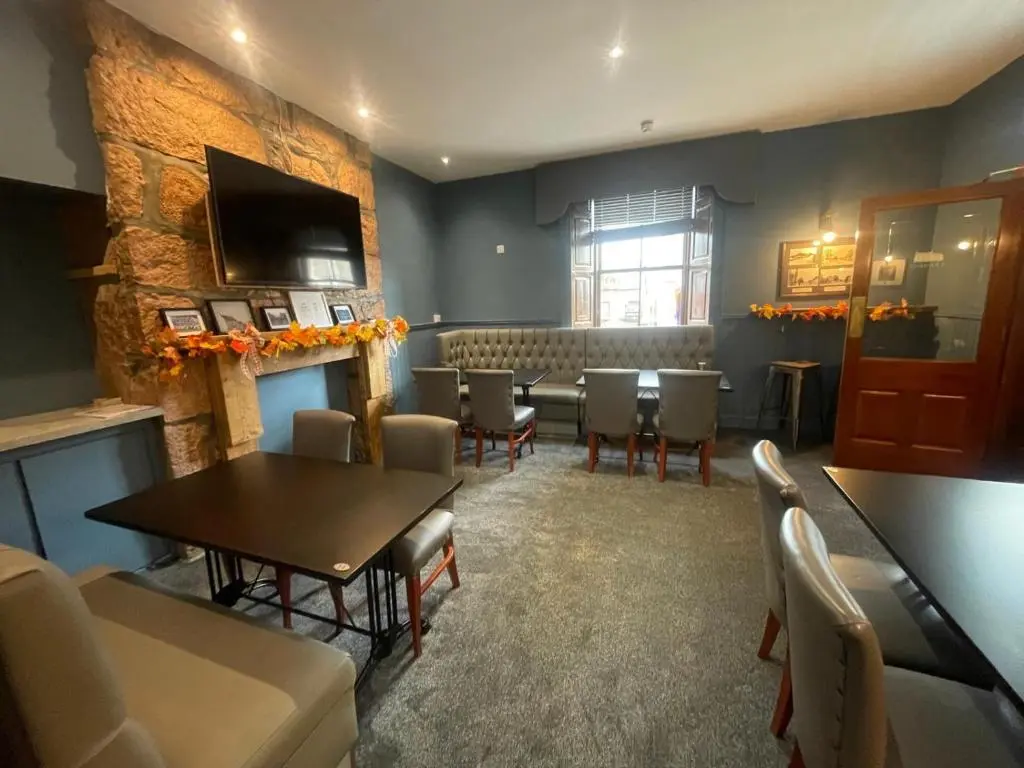 a room with a dining room with a table and chairs at The Square Kintore in Kintore