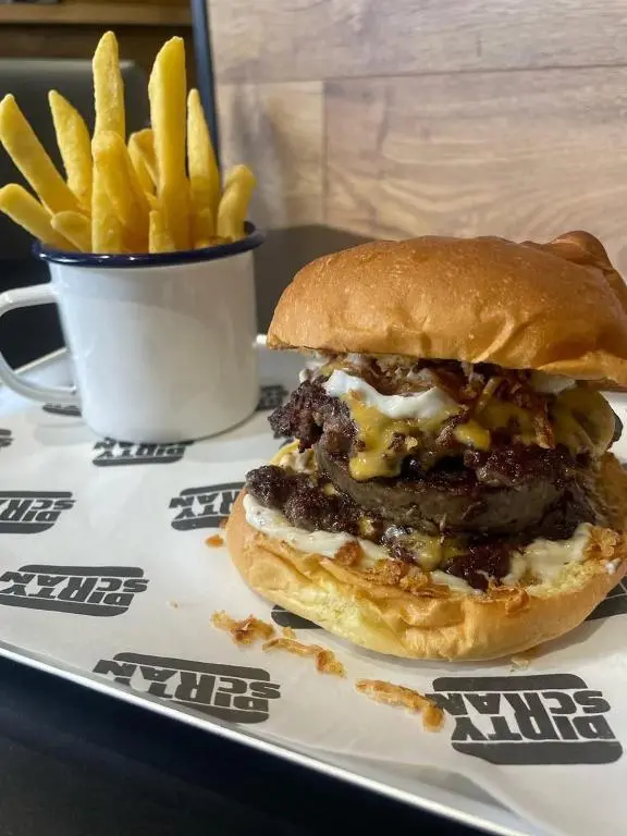 a hamburger and french fries on a plate with a cup of fries at The Square Kintore in Kintore