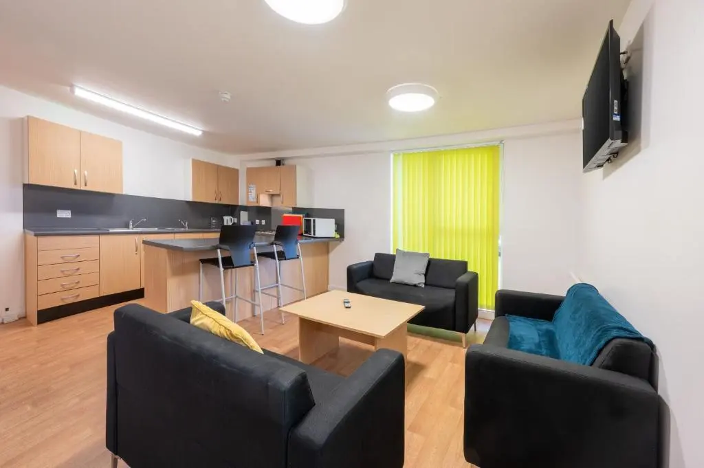 a living room with two couches and a kitchen at UHI Inverness - Campus Accommodation in Inverness