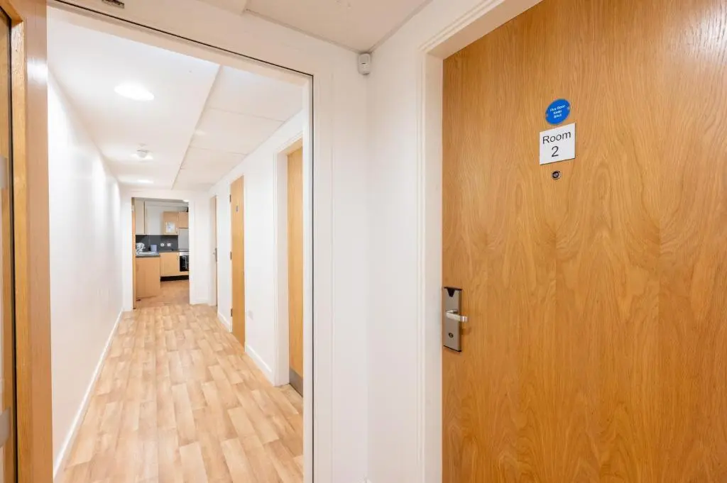 a hallway with a door with a sign on it at UHI Inverness - Campus Accommodation in Inverness