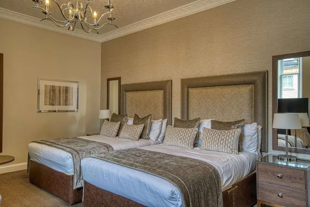a bedroom with two beds and a chandelier at Inverness Palace Hotel & Spa, WorldHotels Distinctive in Inverness