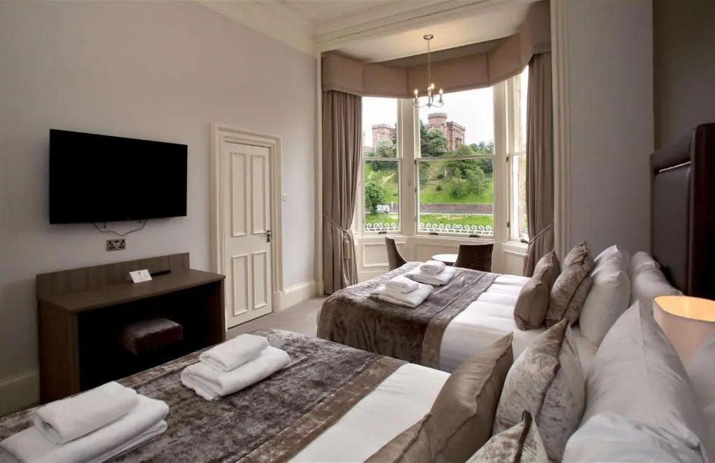 a hotel room with two beds and a flat screen tv at Inverness Palace Hotel & Spa, WorldHotels Distinctive in Inverness