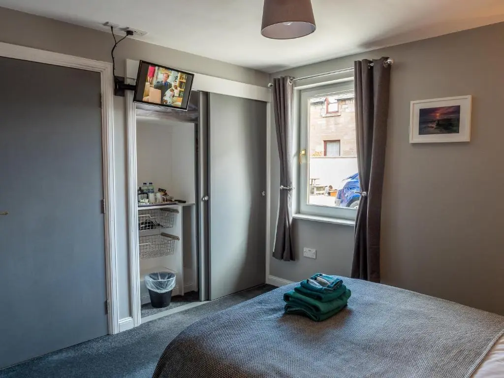 a bedroom with a bed and a window at The Birches in Dingwall