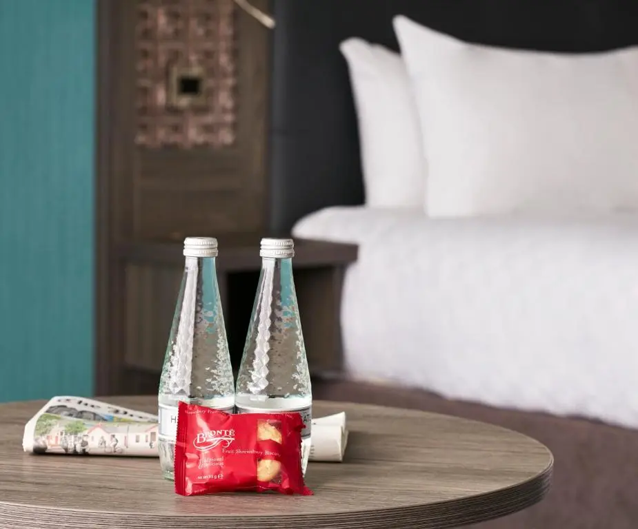 two bottles of soda sitting on a table in a bedroom at Leonardo Hotel Inverness in Inverness