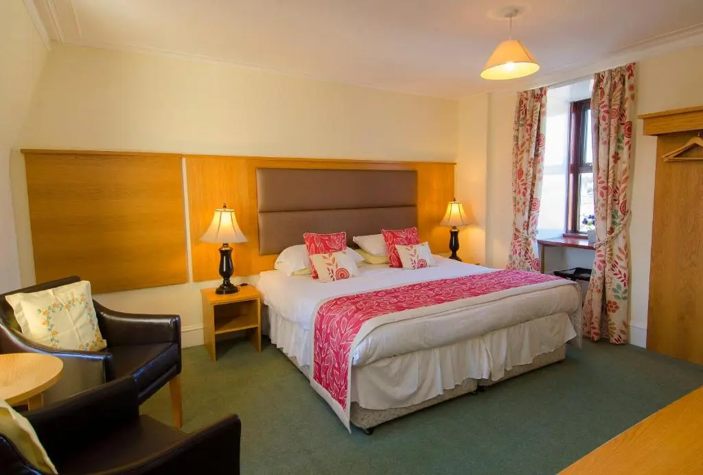 a hotel room with a bed and a chair at The Station Hotel in Portsoy