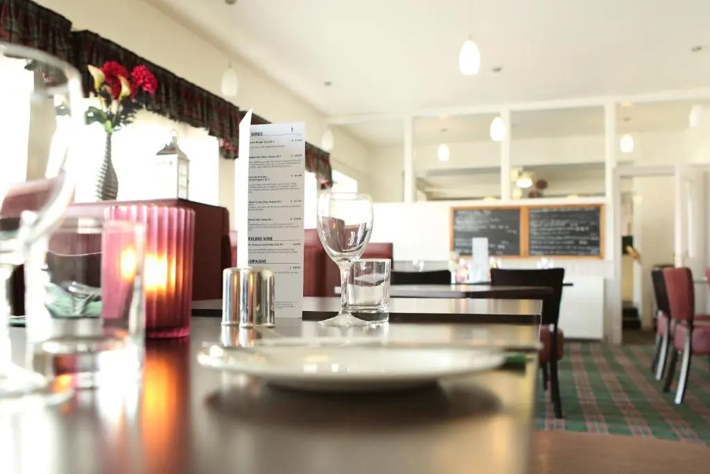 a restaurant with a table with two glasses on it at The Station Hotel in Portsoy