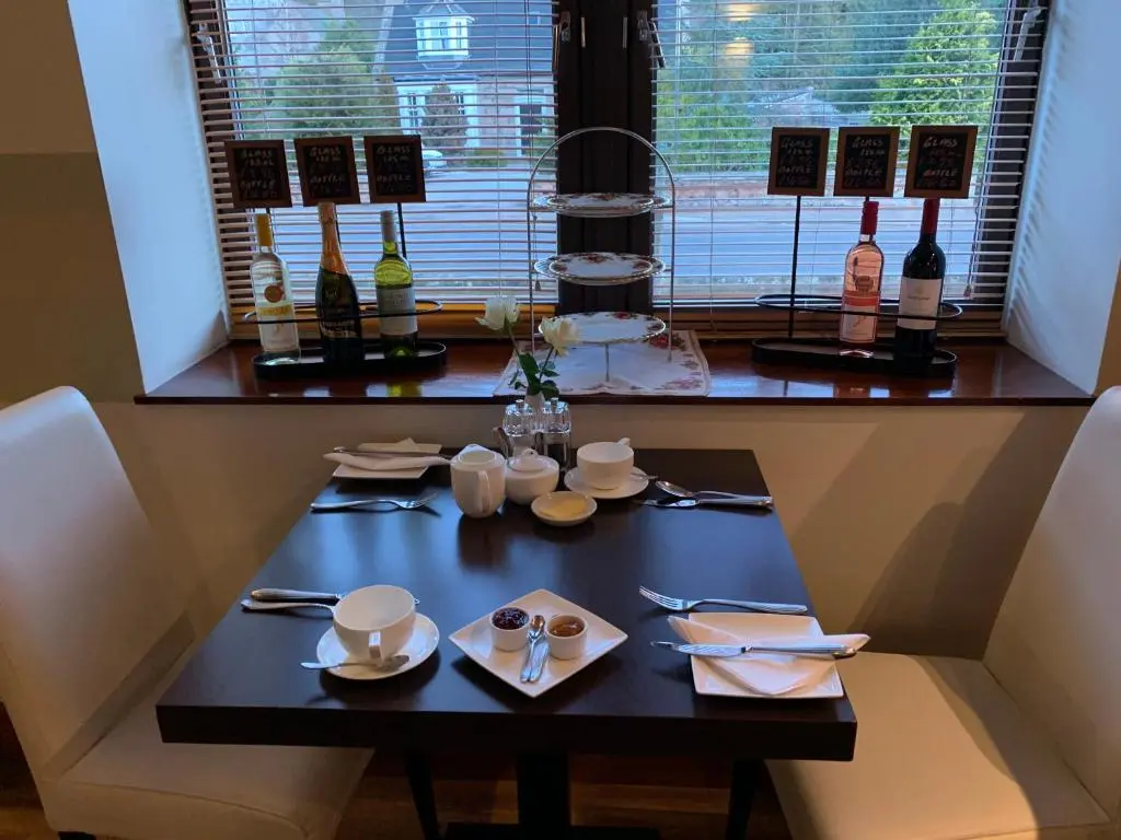 a table with plates and utensils and a window at The Auld Kirk in Ballater