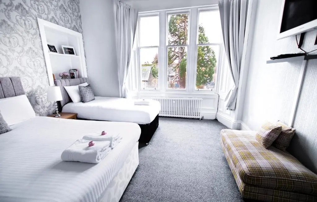 a hotel room with two beds and a couch at McInnes House rooms with breakfast in Kingussie