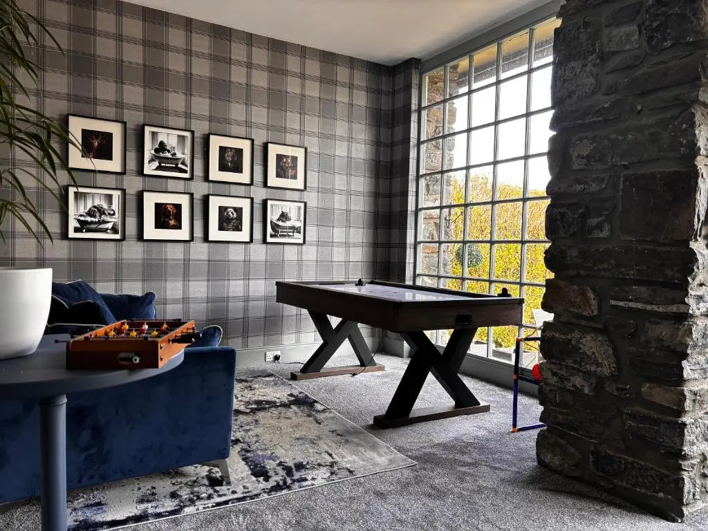 a living room with a ping pong table in front of a window at McInnes House rooms with breakfast in Kingussie