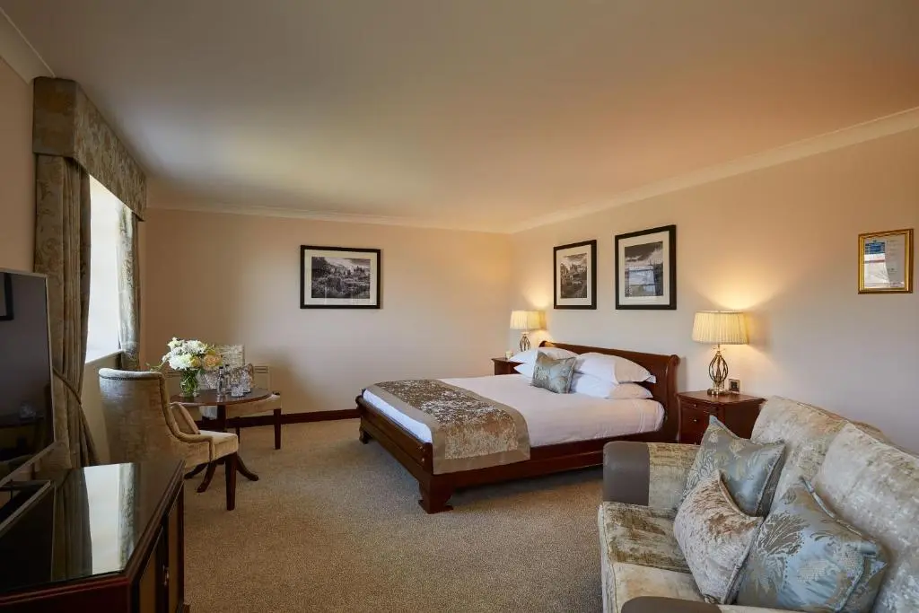 a hotel room with a bed and a couch at Macdonald Drumossie Hotel Inverness in Inverness