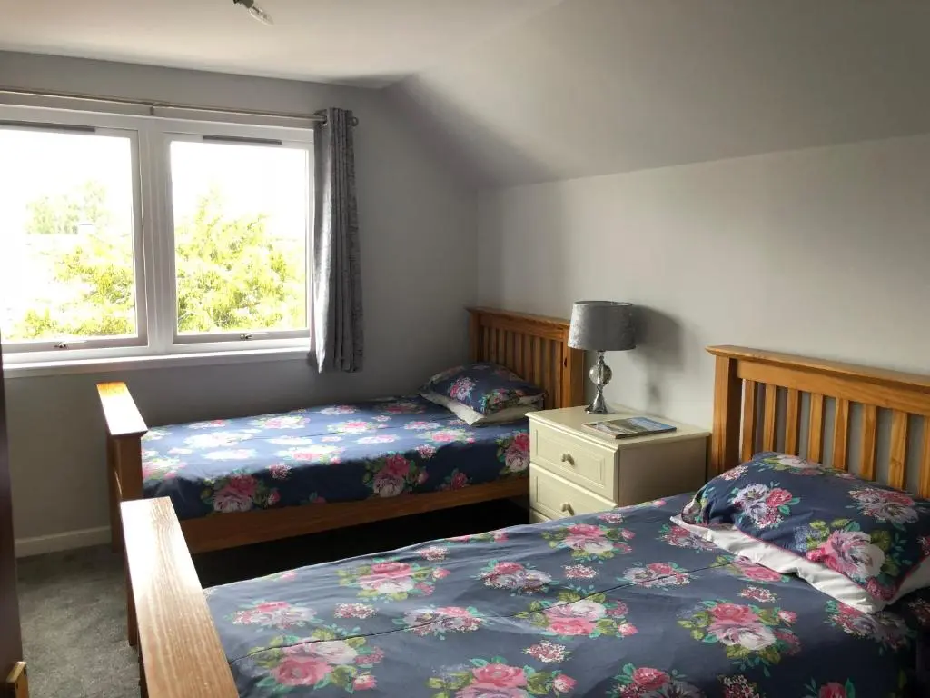 a bedroom with two beds and a window at Fairwinds in Inverness