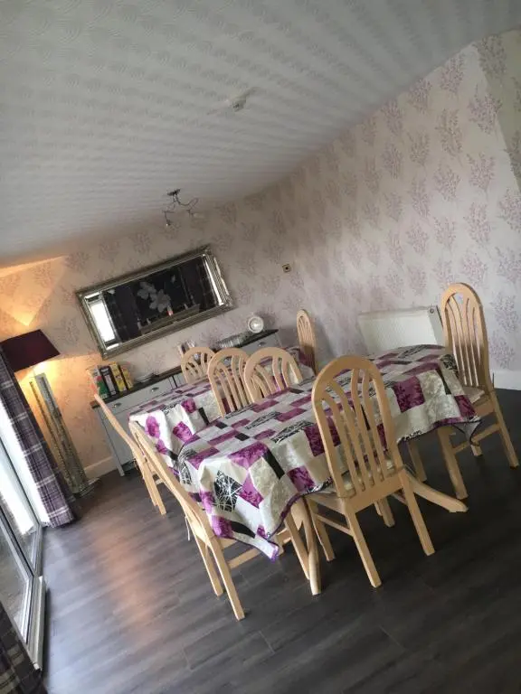 a dining room with a table and chairs and a table and a table and chairs at Fairwinds in Inverness