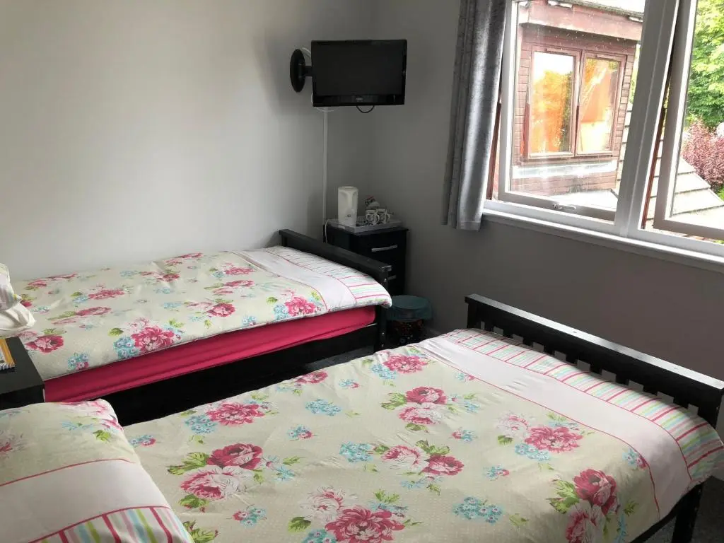 a bedroom with two beds and a window at Fairwinds in Inverness