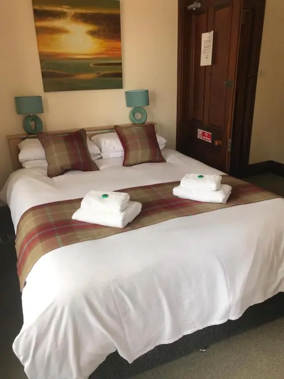 a hotel room with two beds with towels on them at Garfield Guesthouse in Dingwall