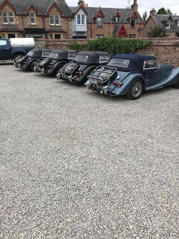a row of classic cars parked in a parking lot at Garfield Guesthouse in Dingwall