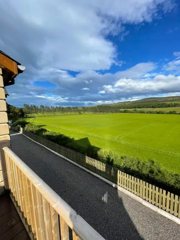 a balcony with a view of a green field at Doura Lodge in Inverness