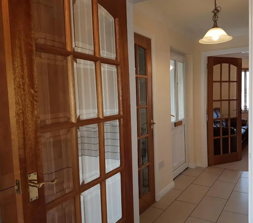 a hallway with wooden doors and a room with a floor at Jane's Villa Free Parking in Inverness