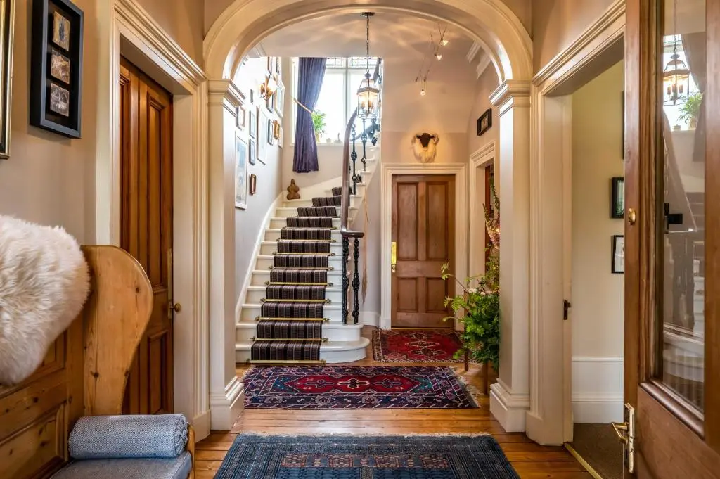 a hallway with a stairway with a stair case at Washington House in Nairn