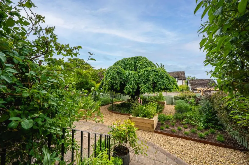 a garden with a fence and a tree at Washington House in Nairn