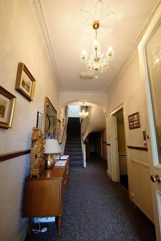 a hallway with a chandelier and a stair case at Talisker Guest House in Inverness