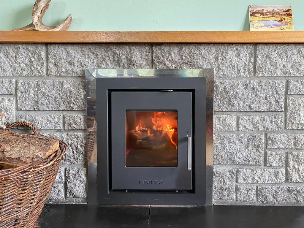 a fireplace in a brick wall at Kintulloch in Insh