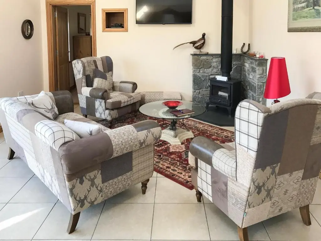 a living room with two couches and a fireplace at Turin Nurin Cottage in Tomatin