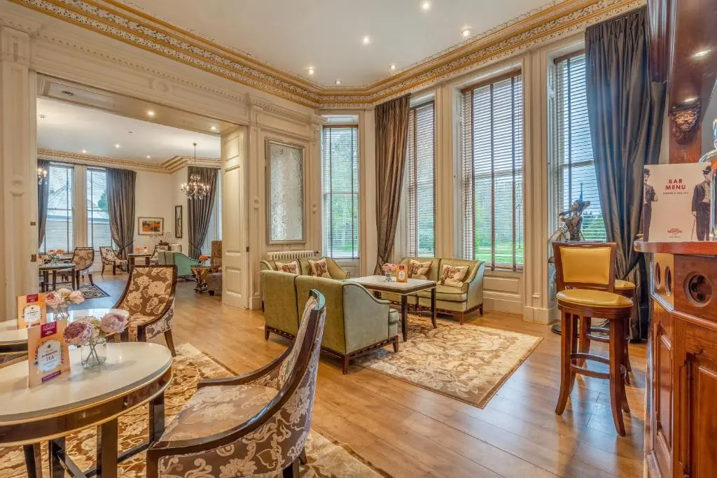 a living room with chairs and tables and windows at Muthu Newton Hotel (Near Inverness Airport) in Nairn