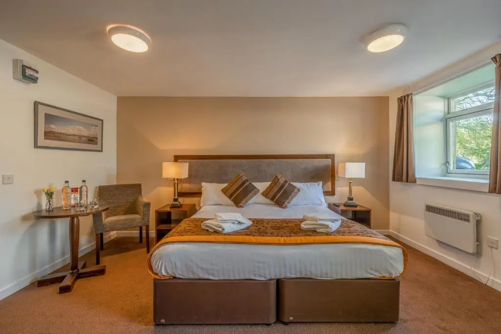 a bedroom with a bed and a desk and a window at Muthu Newton Hotel (Near Inverness Airport) in Nairn
