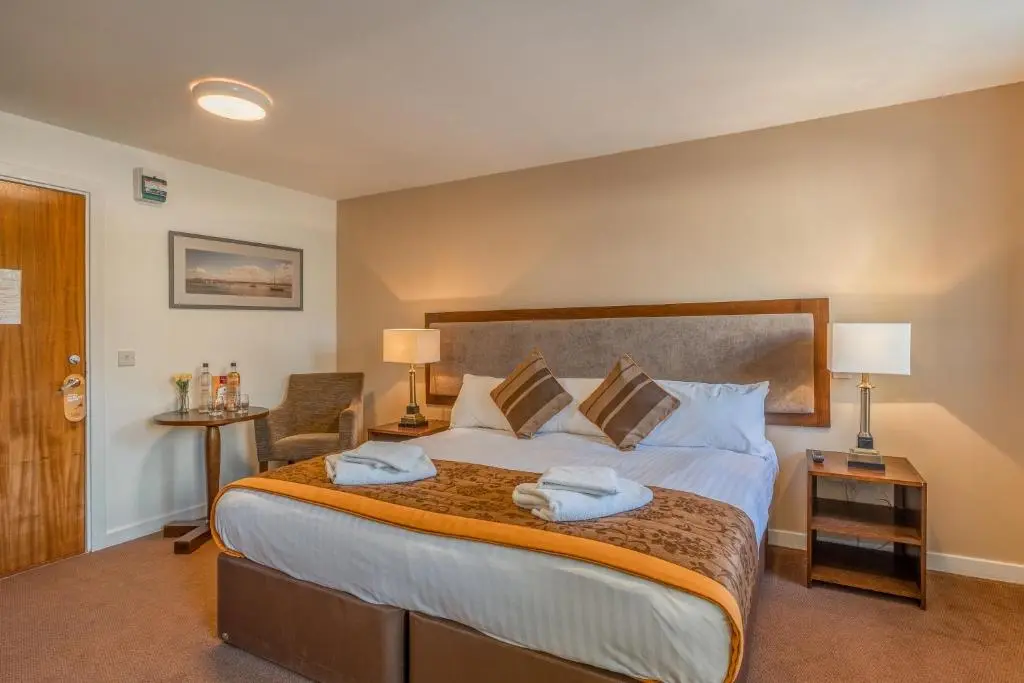 a bedroom with a large bed with towels on it at Muthu Newton Hotel (Near Inverness Airport) in Nairn