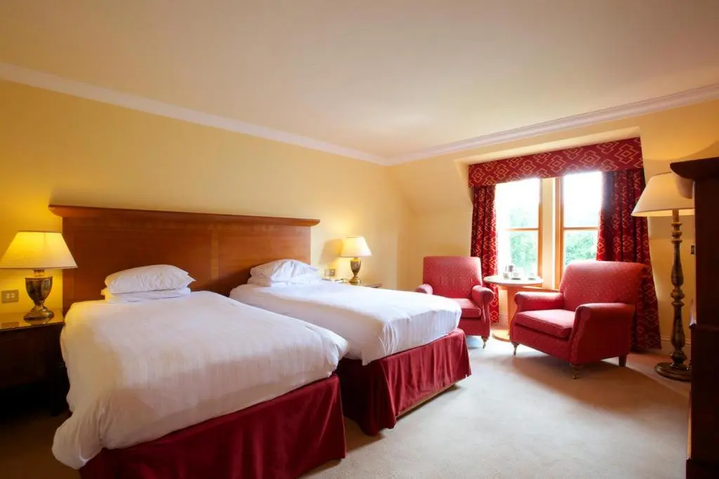 a hotel room with two beds and a window at Muthu Newton Hotel (Near Inverness Airport) in Nairn