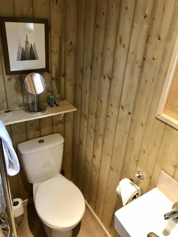 a wooden bathroom with a toilet and a sink at Highland Bear Lodge & Luxury Bear Huts in Drumnadrochit