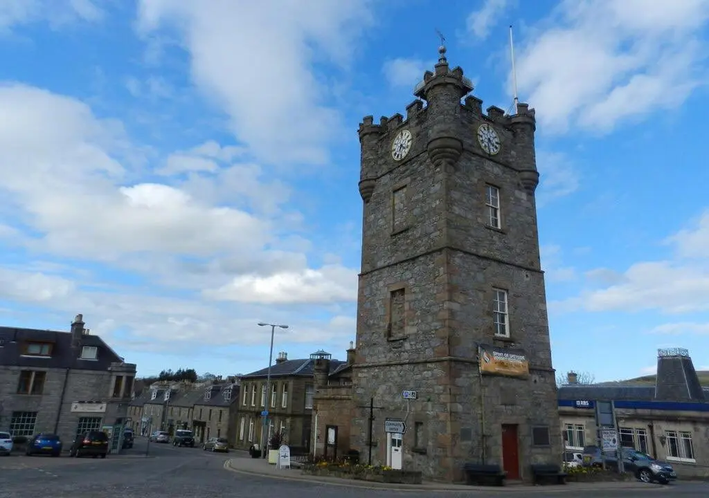 a tall tower with a clock on top of it at Acorn Apartment in Dufftown