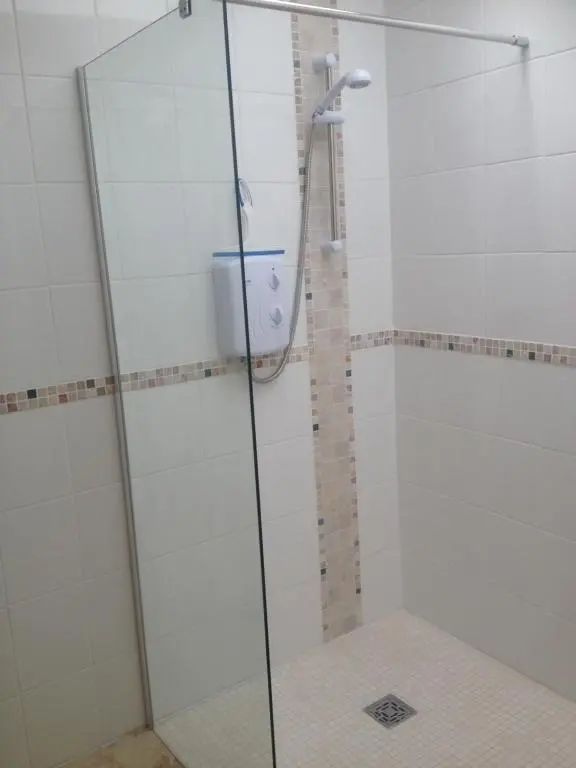 a shower with a glass door in a bathroom at Acorn Apartment in Dufftown