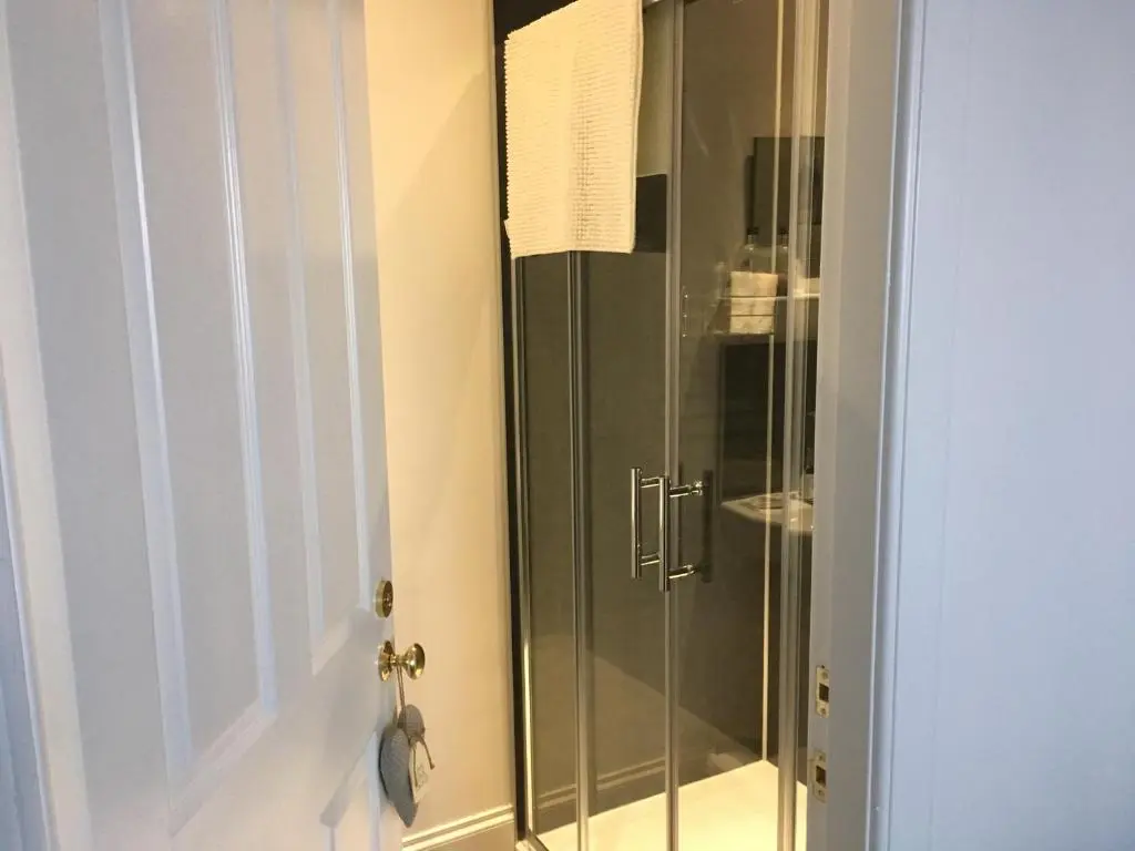 a shower with a glass door in a bathroom at Urrard B&B in Dingwall