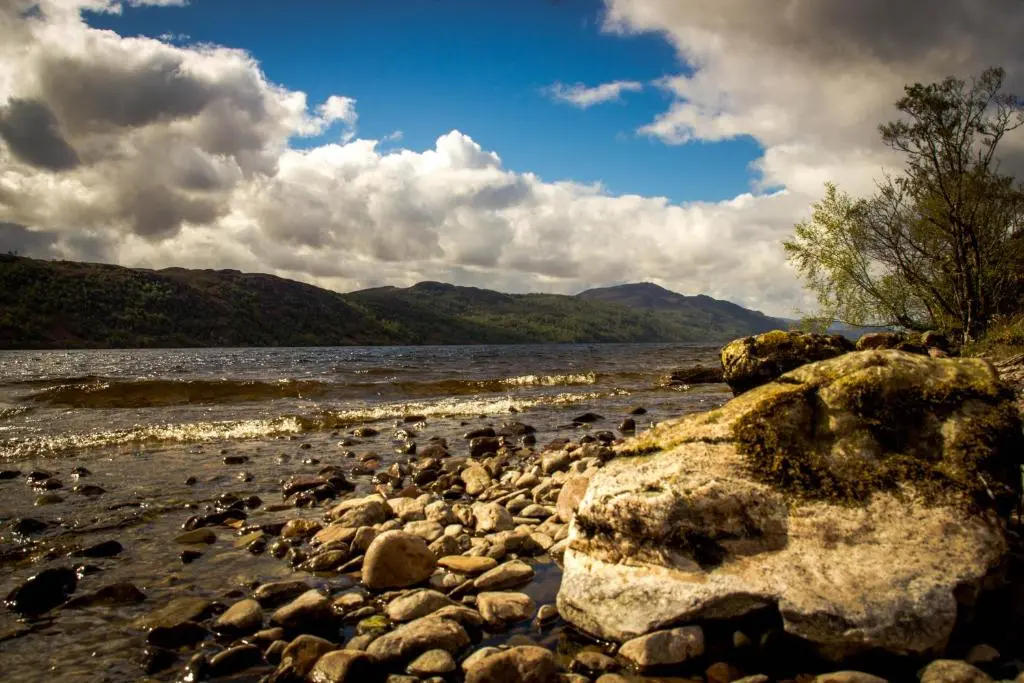 a group of rocks on the shore of a river at Loch Ness Lochside Hostel - Over 16s Only in Invermoriston